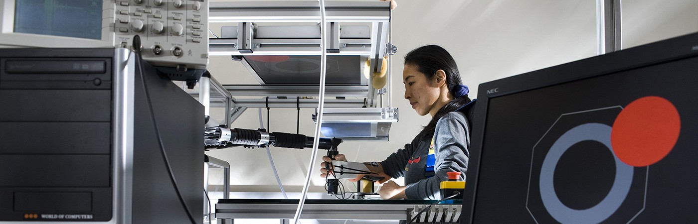 A volunteer doing a reaching experiment while holding a robotic interface.